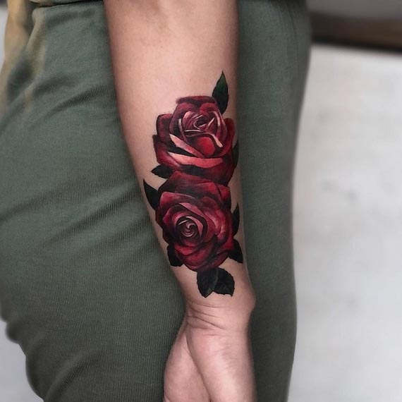 2 red roses with leaves tattoo female forearm