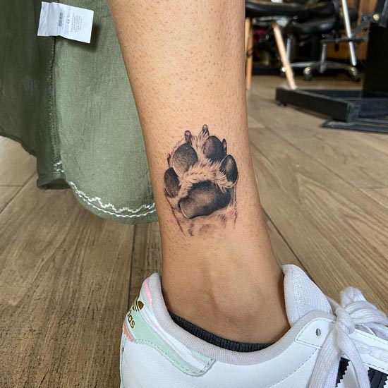 dog paw tattoo design female leg black and grey