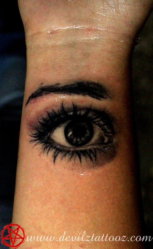 realistic eye black and grey wrist tattoo