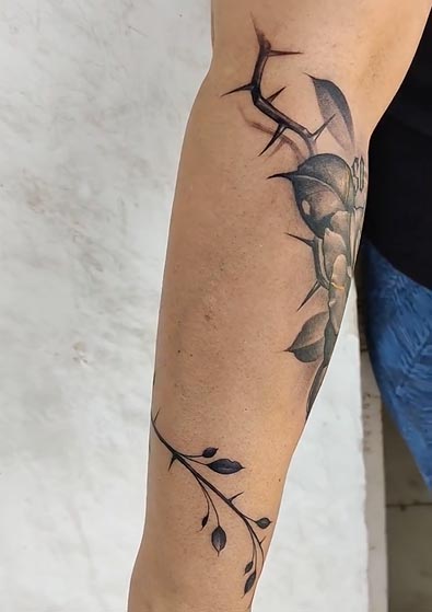 rose thorns around arm tattoo design female