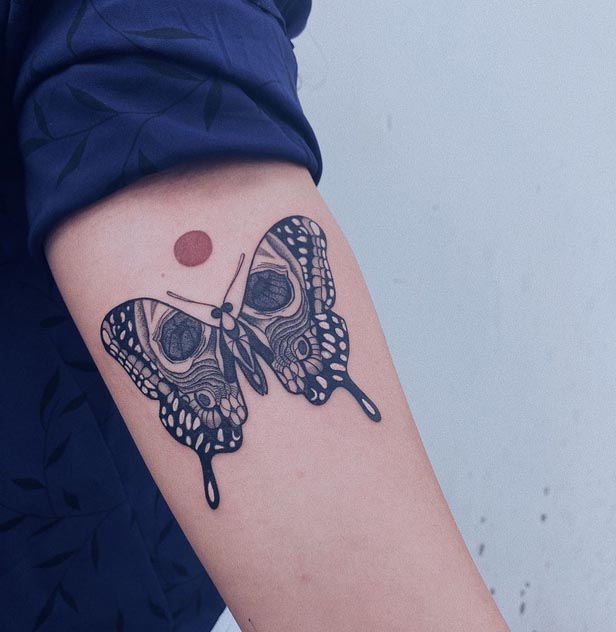 butterfly with skull moon tattoo design female upper forearm