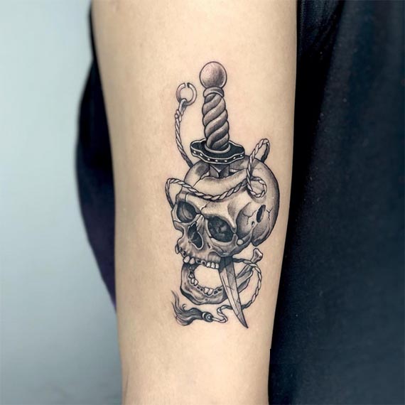 dagger through skull tattoo design male forearm