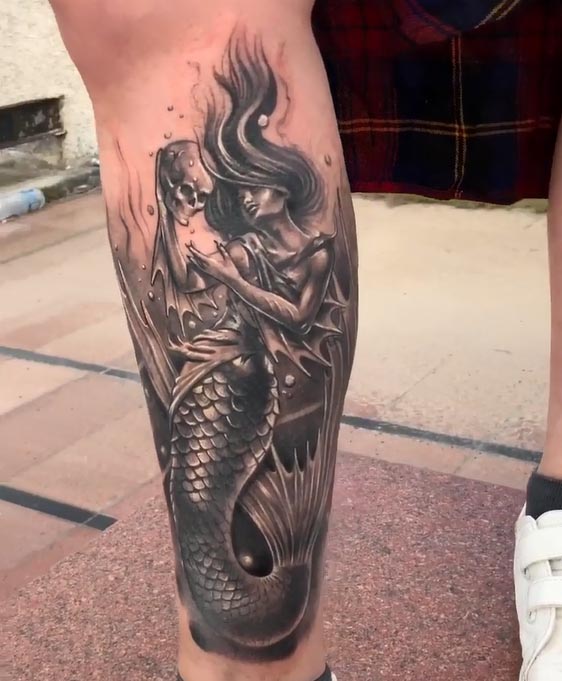 mermaid holding skull tattoo design male leg