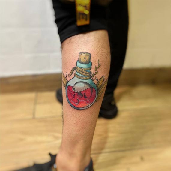new school skull in bulb leaves at background tattoo male leg calf