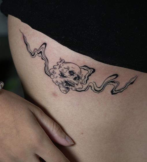 skull fuming smoke with liquid flow background tattoo female side rib