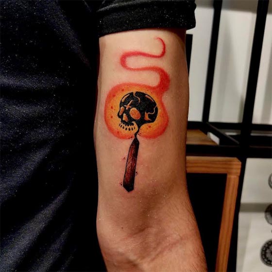 skull in match stick flames unholy color custom tattoo man bicep