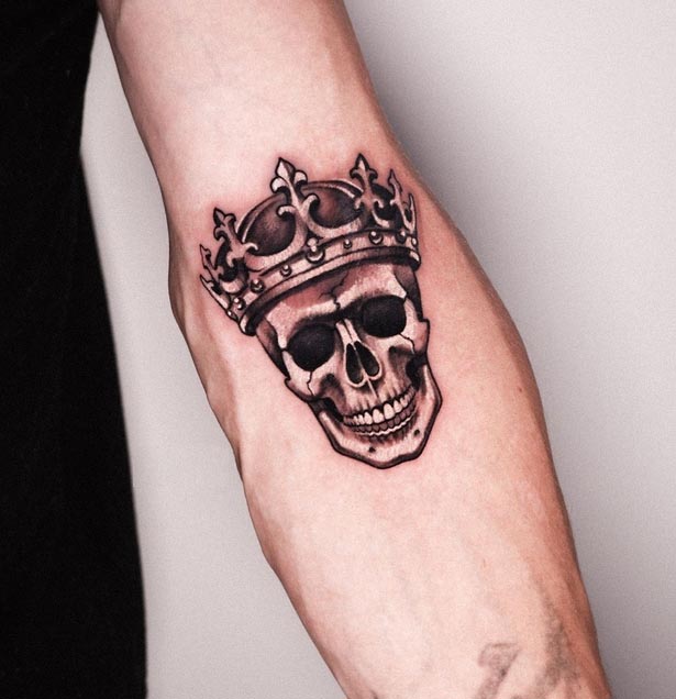 skull with crown tattoo design male forearm