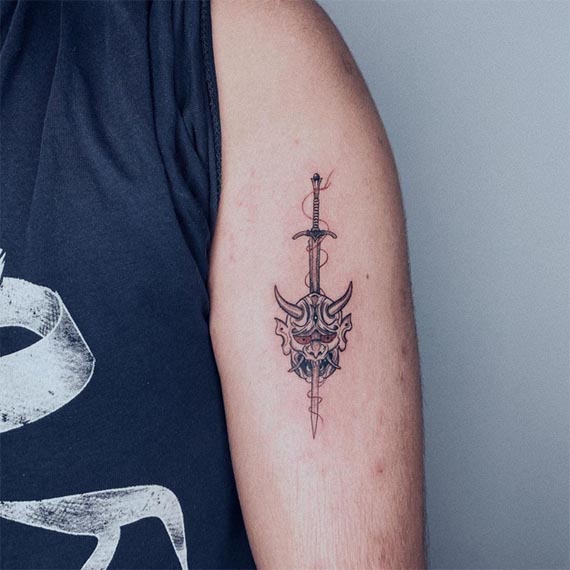 anime sword through japanese mask tattoo male bicep