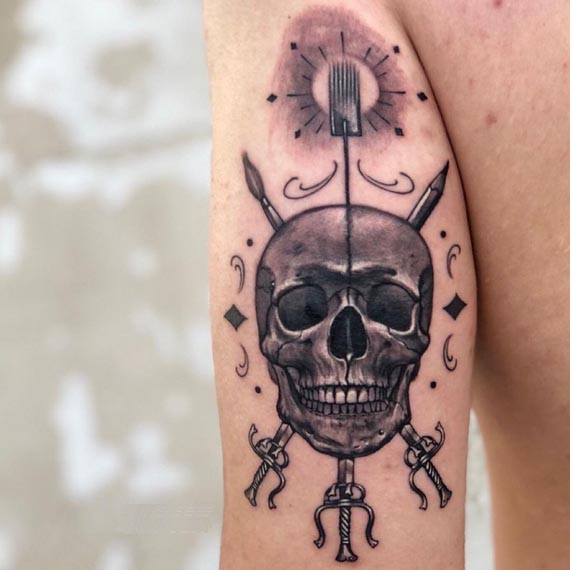 skull 3 crossed swords sun at top tattoo design male bicep