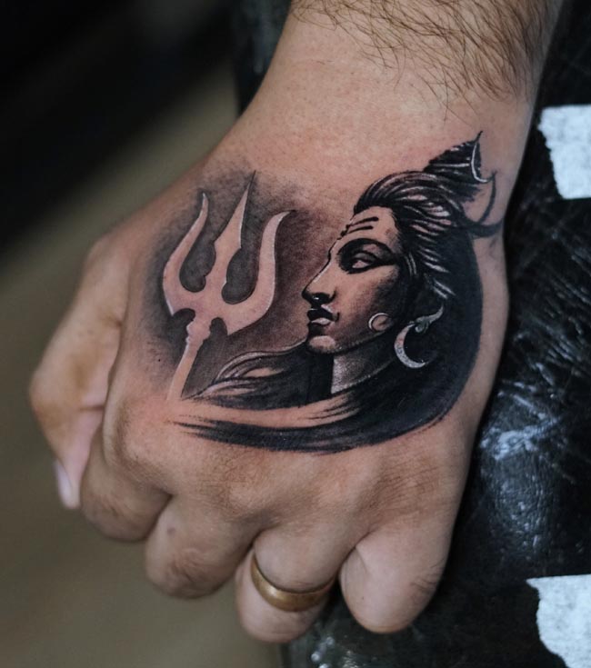 shiva side face with trishul coverup tattoo on male hand