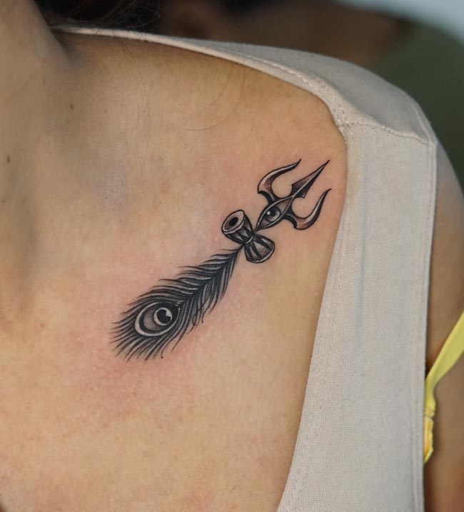 trishul eye damru feather tattoo on female collarbone