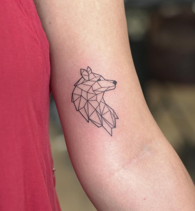 geometric wolf side face tattoo female inner bicep