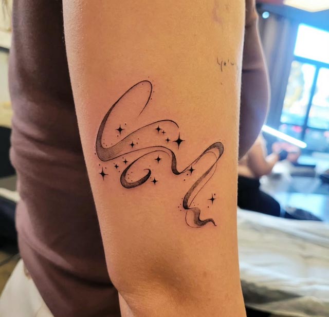 aquarius zodiac sign tattoo constellation on girl lower bicep